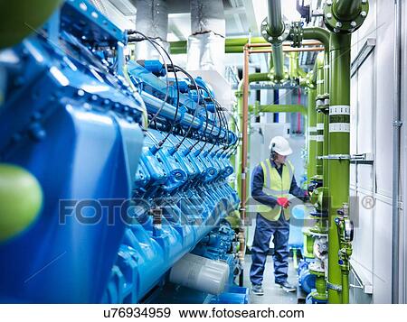 Stock Photo - Worker with gas fired generator in gas fired power station. Fotosearch