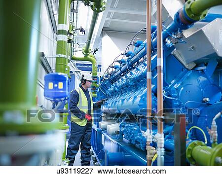 Stock Photo - Worker with gas fired generator in gas fired power station. Fotosearch