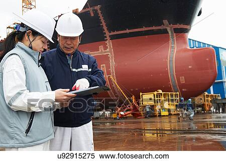 Stock Photography - "Workers discussing plans at shipyard, GoSeong-gun, South Korea". Fotosearch