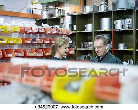 Stock Photo - Workers finding parts in stores in factory. Fotosearch