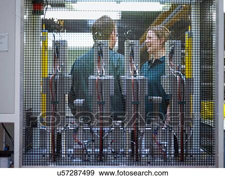 Stock Photo - Workers in discussion on factory floor. Fotosearch