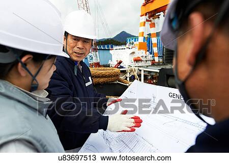 "Workers looking at plans at shipyard, GoSeong-gun, South Korea" View Large Photo Image Stock Image - "Workers looking at plans at shipyard, GoSeong-gun, South Korea". Fotosearch