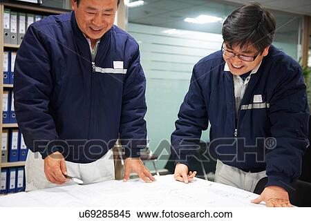 Stock Photography - "Workers looking at ship plans, GoSeong-gun, South Korea". Fotosearch