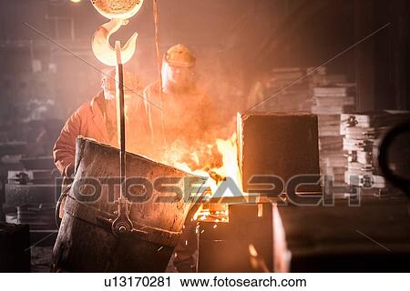 Workers pouring molten metal into moulds from flask in foundry View Large Photo Image Stock Image - Workers pouring molten metal into moulds from flask in foundry. Fotosearch