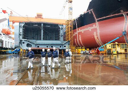 Stock Image - "Workers walking across shipyard, GoSeong-gun, South Korea". Fotosearch