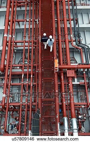 "Workers walking along walkway at shipping port, elevated view, GoSeong-gun, South Korea" View Large Photo Image Stock Photograph - "Workers walking along walkway at shipping port, elevated view, GoSeong-gun, South Korea". Fotosearch