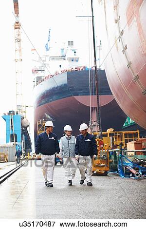 "Workers walking through shipyard, GoSeong-gun, South Korea" View Large Photo Image Stock Photo - "Workers walking through shipyard, GoSeong-gun, South Korea". Fotosearch
