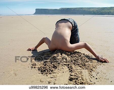 Young boy with head buried in sand on beach View Large Photo Image Stock Photograph - Young boy with head buried in sand on beach. Fotosearch