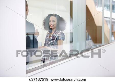 Young businesswoman and man chatting in office meeting View Large Photo Image Stock Photo - Young businesswoman and man chatting in office meeting. Fotosearch
