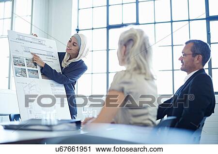 Young businesswoman presenting ideas to business team in office View Large Photo Image Stock Image - Young businesswoman presenting ideas to business team in office. Fotosearch