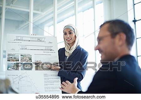 Young businesswoman presenting ideas to businessman in office View Large Photo Image Stock Photography - Young businesswoman presenting ideas to businessman in office. Fotosearch