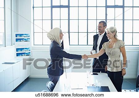 Young businesswoman shaking hands with businesswoman in office View Large Photo Image Stock Photograph - Young businesswoman shaking hands with businesswoman in office. Fotosearch