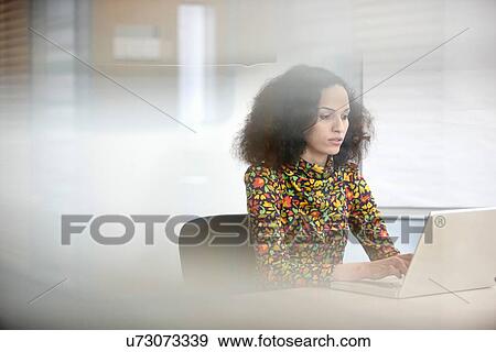 Young businesswoman using computer at office desk View Large Photo Image Stock Photo - Young businesswoman using computer at office desk. Fotosearch