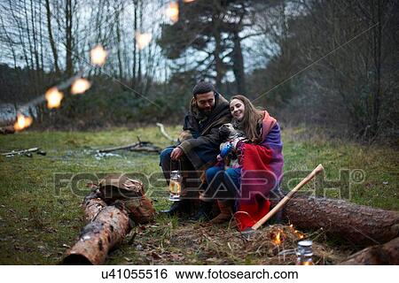 Young camping couple with dog wrapped in blanket in woods View Large Photo Image Stock Photograph - Young camping couple with dog wrapped in blanket in woods. Fotosearch