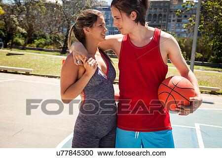 Stock Image - Young couple at basketball court. Fotosearch