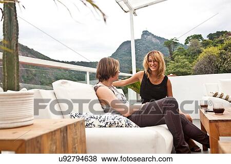 "Young couple chatting on rooftop terrace sofa, Rio De Janeiro, Brazil" View Large Photo Image Stock Photo - "Young couple chatting on rooftop terrace sofa, Rio De Janeiro, Brazil". Fotosearch