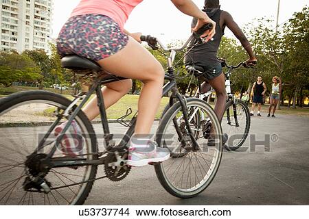 Young couple cycling in park View Large Photo Image Picture - Young couple cycling in park. Fotosearch
