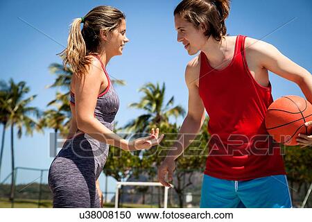 Young couple flirting whilst playing basketball View Large Photo Image Stock Image - Young couple flirting whilst playing basketball. Fotosearch