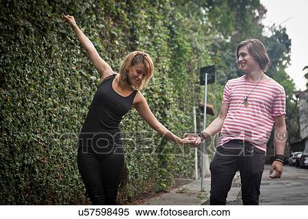 Young couple fooling around on suburban street View Large Photo Image Stock Photography - Young couple fooling around on suburban street. Fotosearch