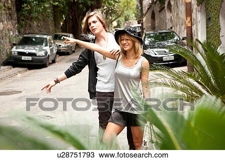 Stock Image - "Young couple hailing a taxi on street, Rio De Janeiro, Brazil". Fotosearch