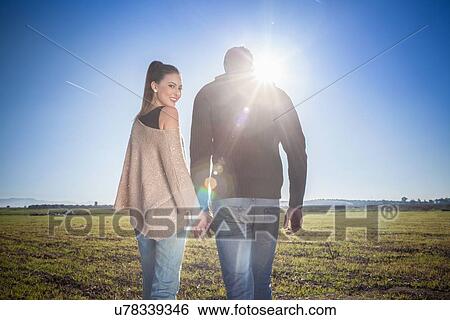 Young couple holding hands in field View Large Photo Image Stock Photograph - Young couple holding hands in field. Fotosearch