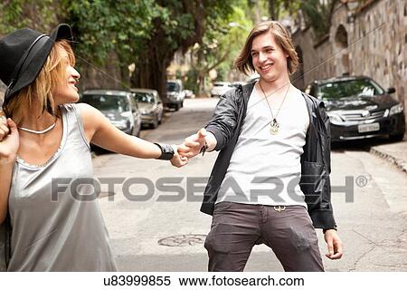 Stock Photography - "Young couple holding hands on street, Rio De Janeiro, Brazil". Fotosearch