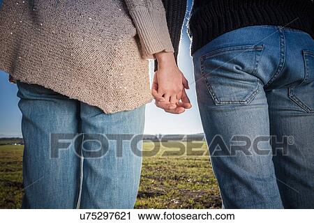 "Young couple holding hands, rear view" View Large Photo Image Stock Image - "Young couple holding hands, rear view". Fotosearch