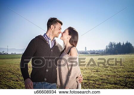Young couple hugging in field View Large Photo Image Picture - Young couple hugging in field. Fotosearch