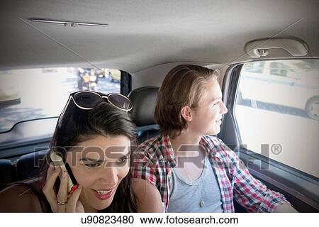 "Young couple in car, woman on cell phone" View Large Photo Image Stock Image - "Young couple in car, woman on cell phone". Fotosearch