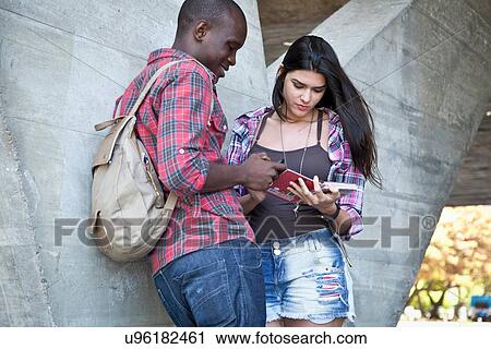 Stock Image - Young couple looking at notebook. Fotosearch