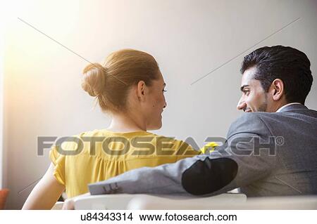 Picture - "Young couple sitting inside cafe, rear view". Fotosearch