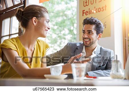 "Young couple sitting inside cafe, talking, low angle view" View Large Photo Image Stock Image - "Young couple sitting inside cafe, talking, low angle view". Fotosearch