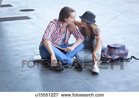 Stock Photo - Young couple sitting on floor. Fotosearch