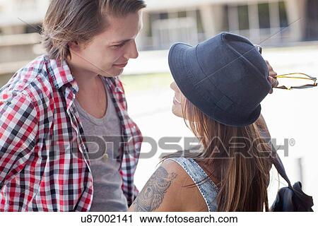 "Young couple smiling, woman wearing hat" View Large Photo Image Stock Image - "Young couple smiling, woman wearing hat". Fotosearch