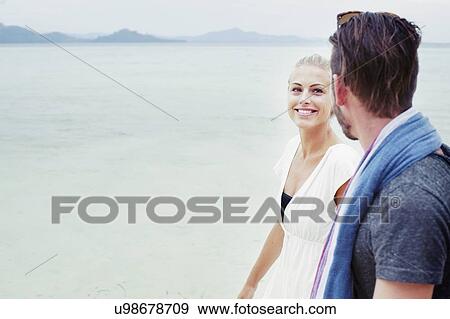 Stock Photo - "Young couple strolling on beach, Kradan, Thailand". Fotosearch