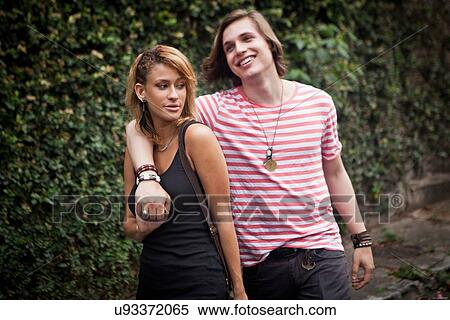 Young couple strolling on suburban street View Large Photo Image Stock Photography - Young couple strolling on suburban street. Fotosearch