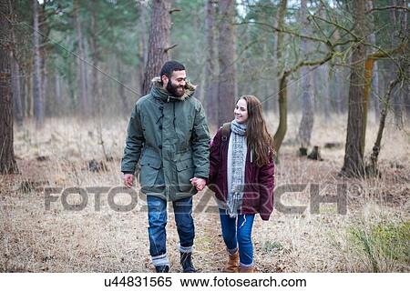 Young couple strolling together in forest View Large Photo Image Stock Photography - Young couple strolling together in forest. Fotosearch