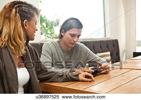 Young couple using digital tablet in hotel lobby View Large Photo Image Stock Photography - Young couple using digital tablet in hotel lobby. Fotosearch