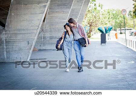 Stock Photo - Young couple walking by building. Fotosearch