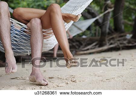 "Young couples legs on beach hammock, Kradan, Thailand" View Large Photo Image Stock Image - "Young couples legs on beach hammock, Kradan, Thailand". Fotosearch