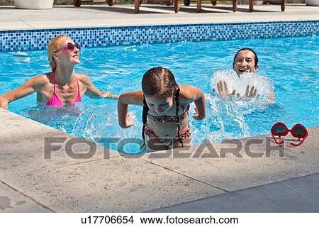 Young family fooling around in outdoor pool View Large Photo Image Picture - Young family fooling around in outdoor pool. Fotosearch
