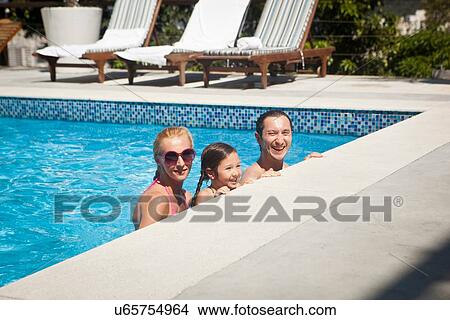 Picture - Young family in swimming pool together. Fotosearch