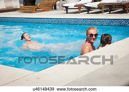 Young family in swimming pool together View Large Photo Image Stock Photo - Young family in swimming pool together. Fotosearch