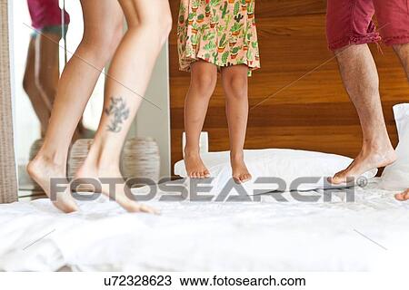"Young family jumping on bed, low section" View Large Photo Image Stock Image - "Young family jumping on bed, low section". Fotosearch