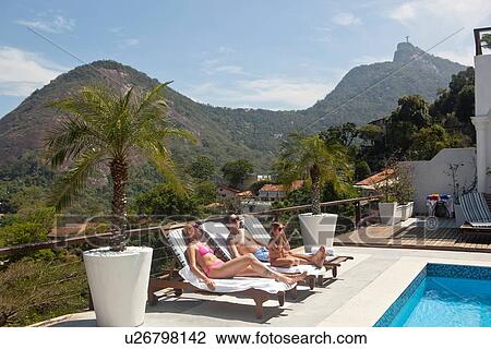 "Young family sunbathing by pool, Rio de Janeiro, Brazil" View Large Photo Image Stock Image - "Young family sunbathing by pool, Rio de Janeiro, Brazil". Fotosearch