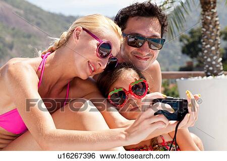 Stock Photograph - Young family taking self portrait with camera. Fotosearch