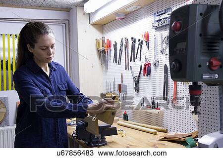 Young female carpenter planing timber in workshop vice View Large Photo Image Stock Image - Young female carpenter planing timber in workshop vice. Fotosearch