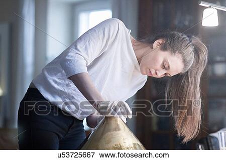 Stock Photo - Young female craftswoman in workshop. Fotosearch