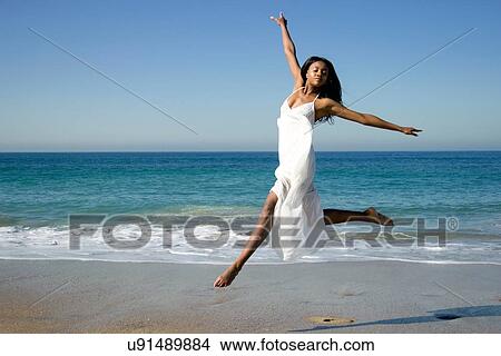Young female dancer leaping mid air on beach View Large Photo Image Picture - Young female dancer leaping mid air on beach. Fotosearch