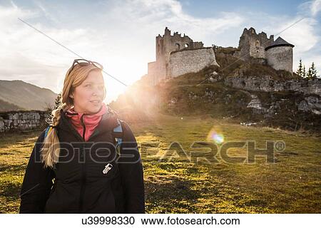 Stock Image - "Young female hiker in front of Ehrenberg castle ruins, Reutte, Tyrol, Austria". Fotosearch